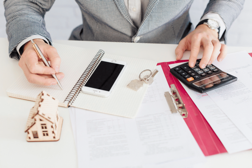 an individual writing while using a calculator 