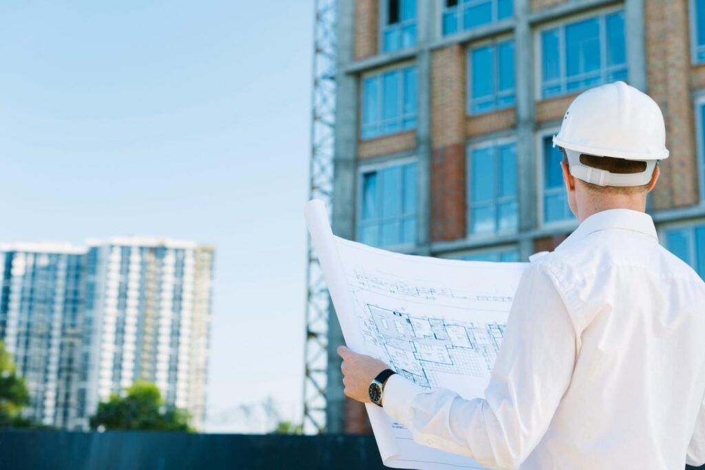 an engineer viewing the blue print of a new construction project