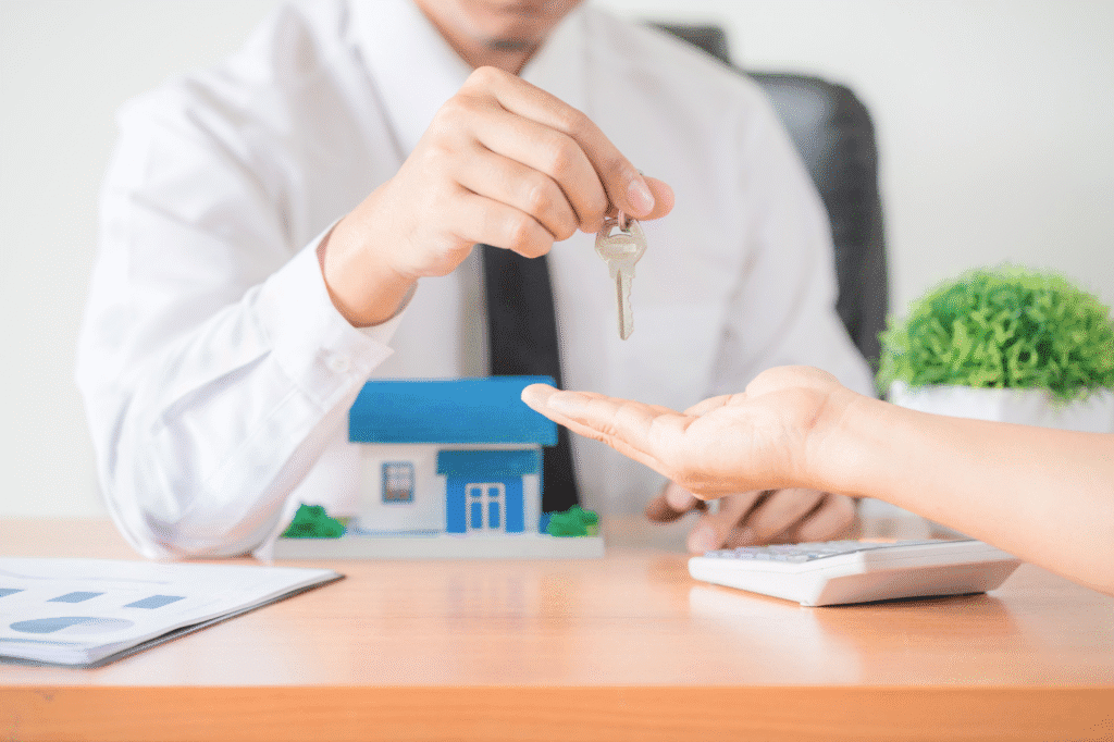 an individual handing over a key to another