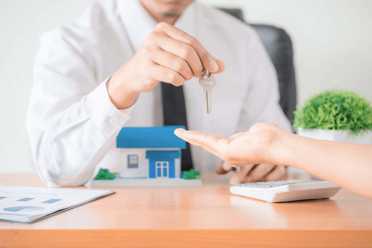 an individual handing over a key to another