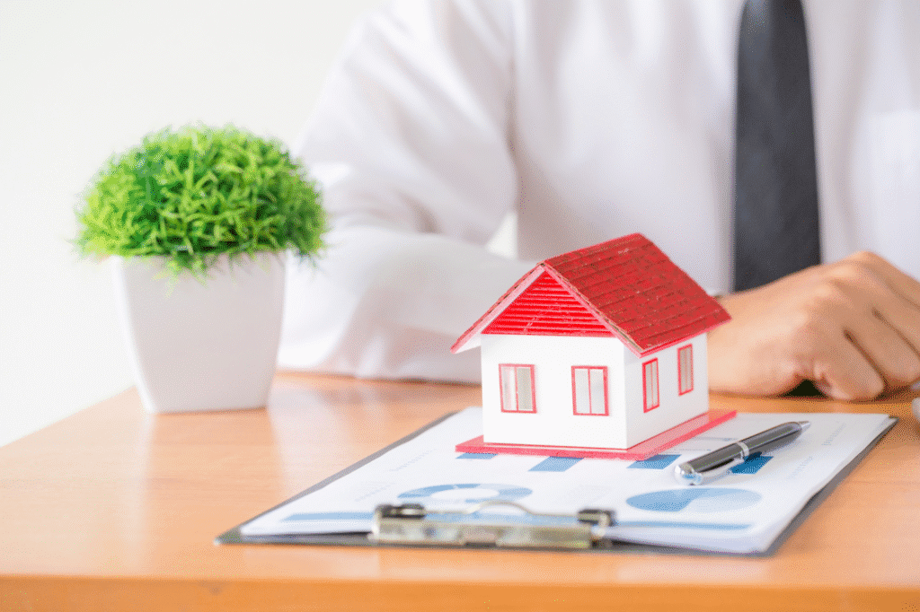 a house shaped figurine placed on a bunch of documents
