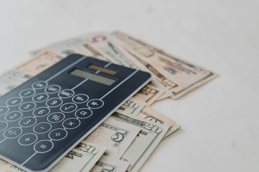 Black calculator resting on top of assorted banknotes