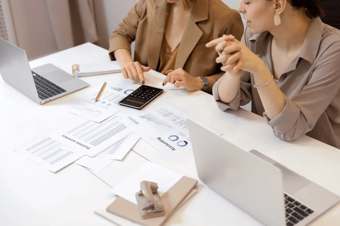 2 businesswomen discussing financial documents in a modern office