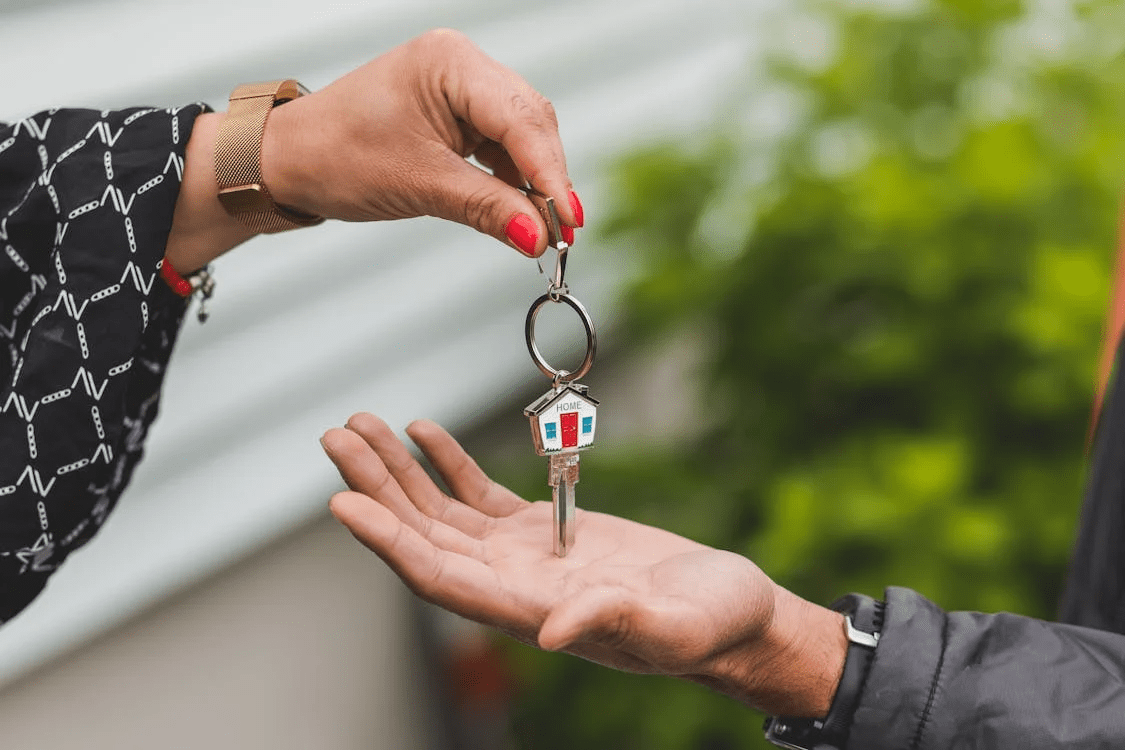 One person handing a home key to another
