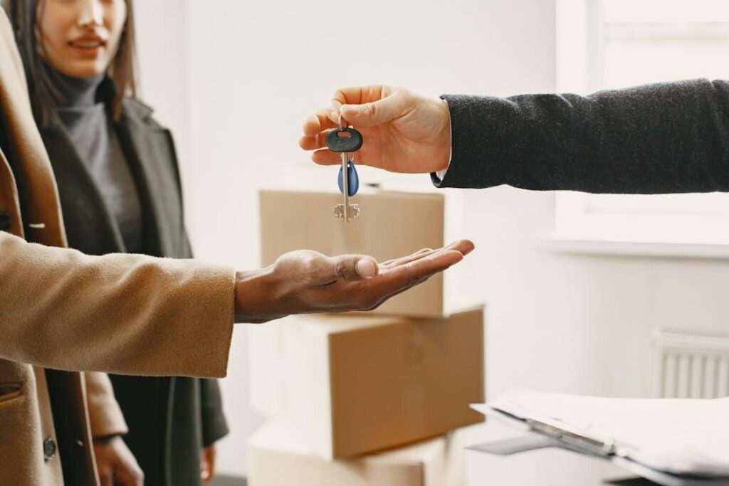 A person giving another person the key to their new house.