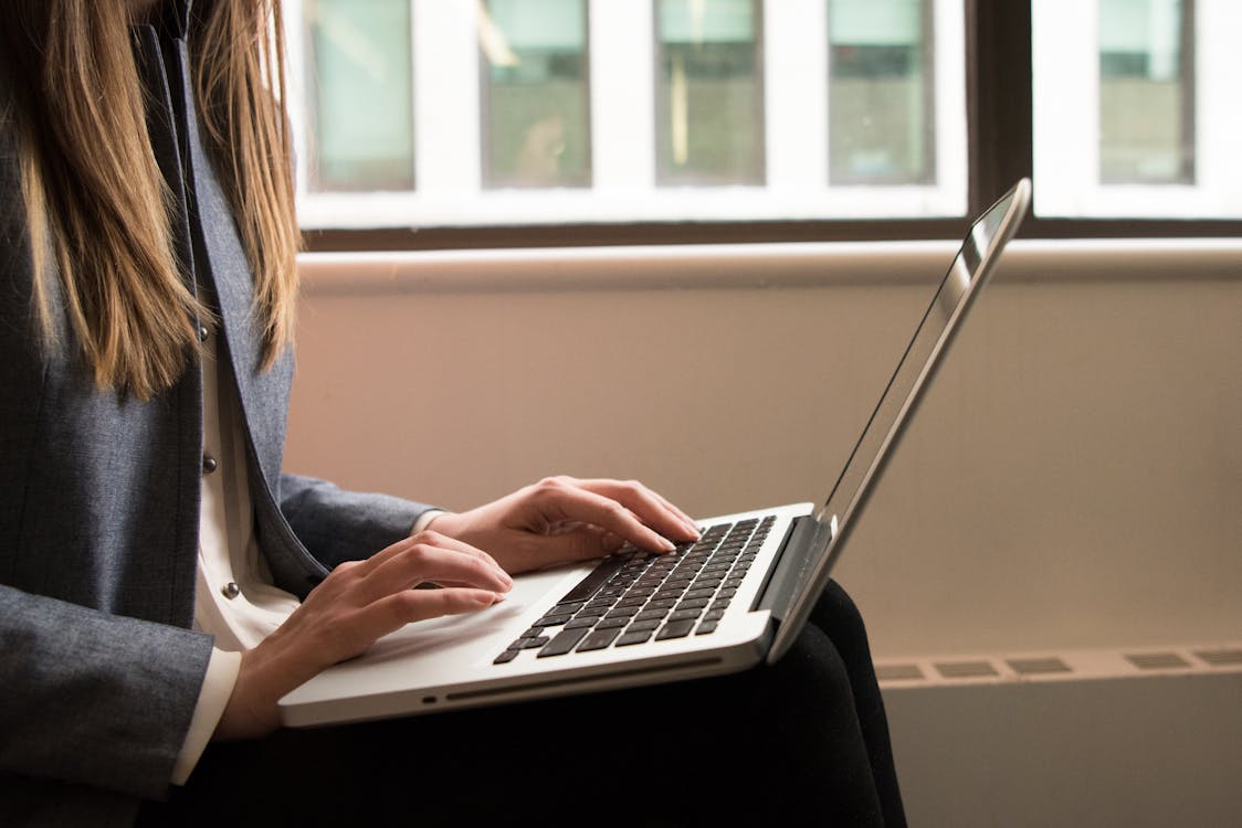 An image of a person typing on a laptop