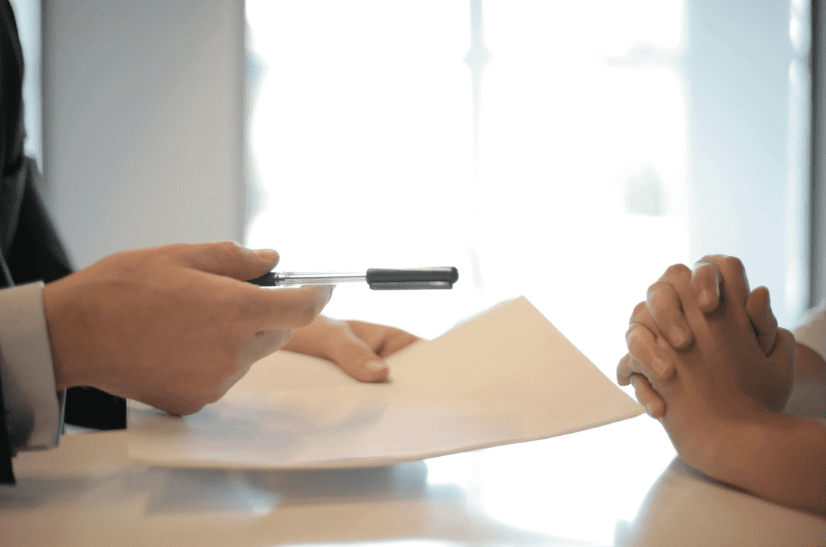 A person signing a document for a cash-out refinance loan.
