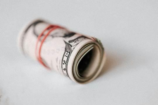 A rolled wad of dollar bills