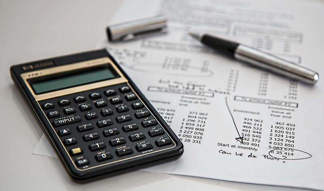 Calculator and financial papers representing real estate loan planning with private capital.