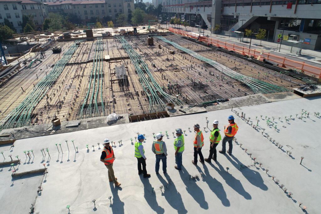 Seven construction workers standing together on a bright work site