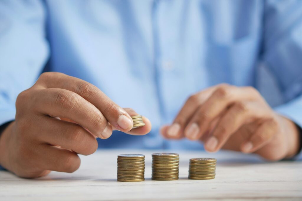 A person stacking coins on a table