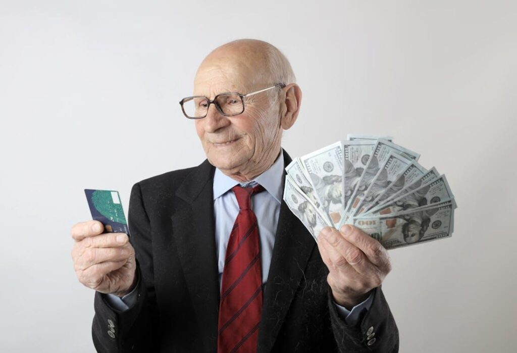 A person holding a credit card and some money in their hands
