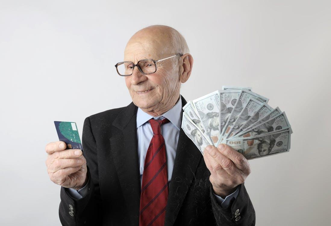 A person holding a credit card and some money in their hands