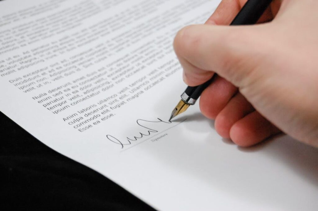 Image of a hand signing a document