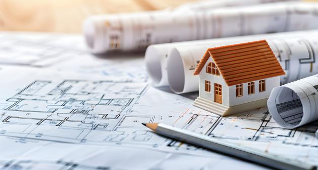 This photo shows a small model house on a blueprint.