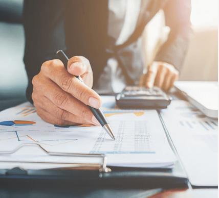 A person calculating loans with a pen and paper