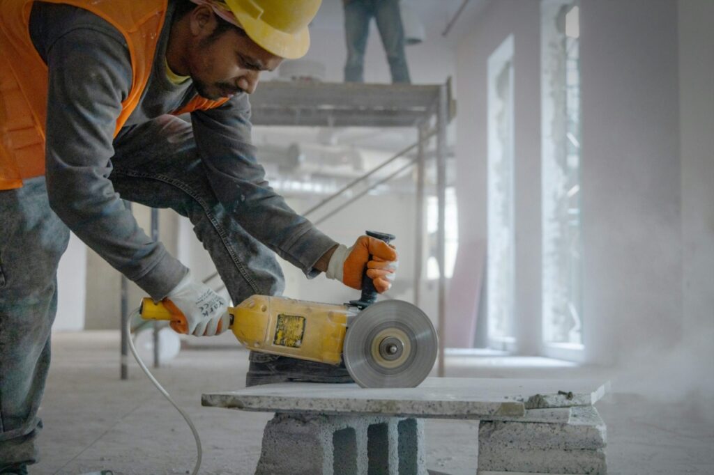 Worker using a power grinder on a concrete surface