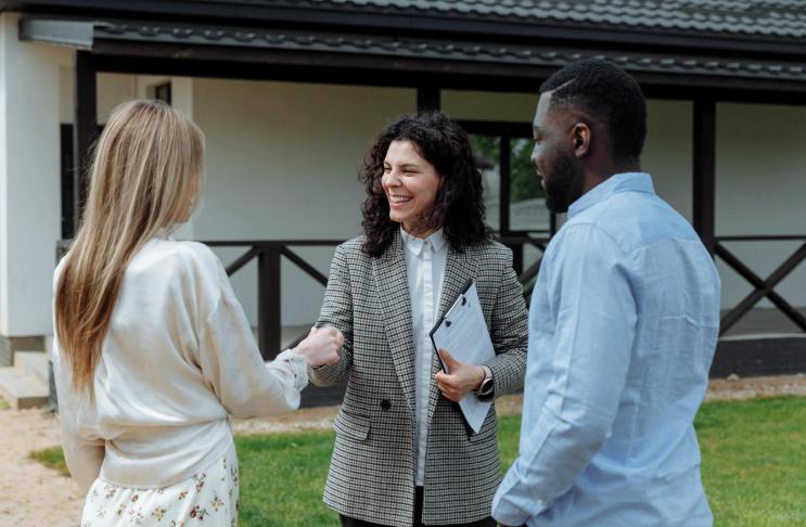 This photo shows a couple shaking hands with a financial partner.