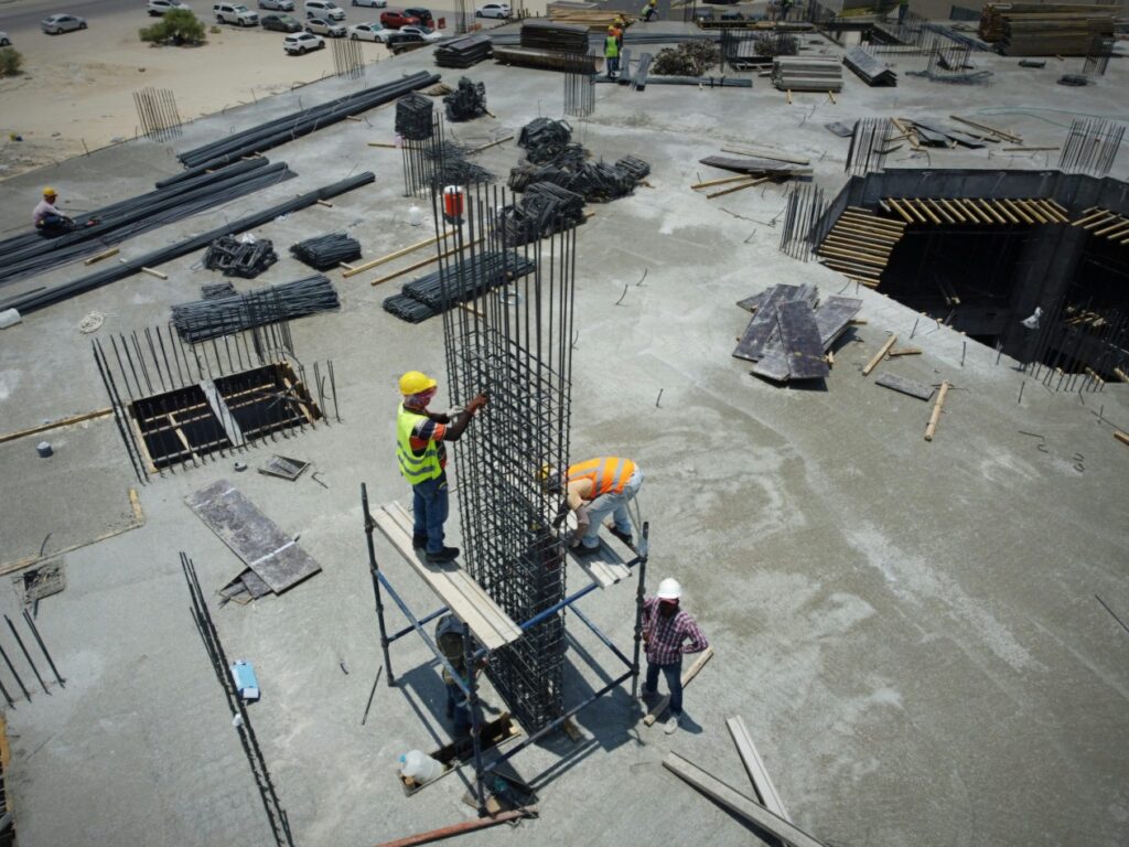 Group of men standing together on a construction site setting up a frame