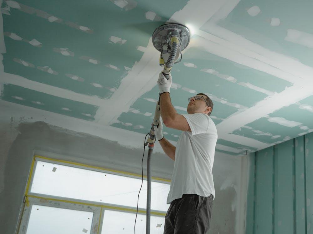 A man polishing the ceiling