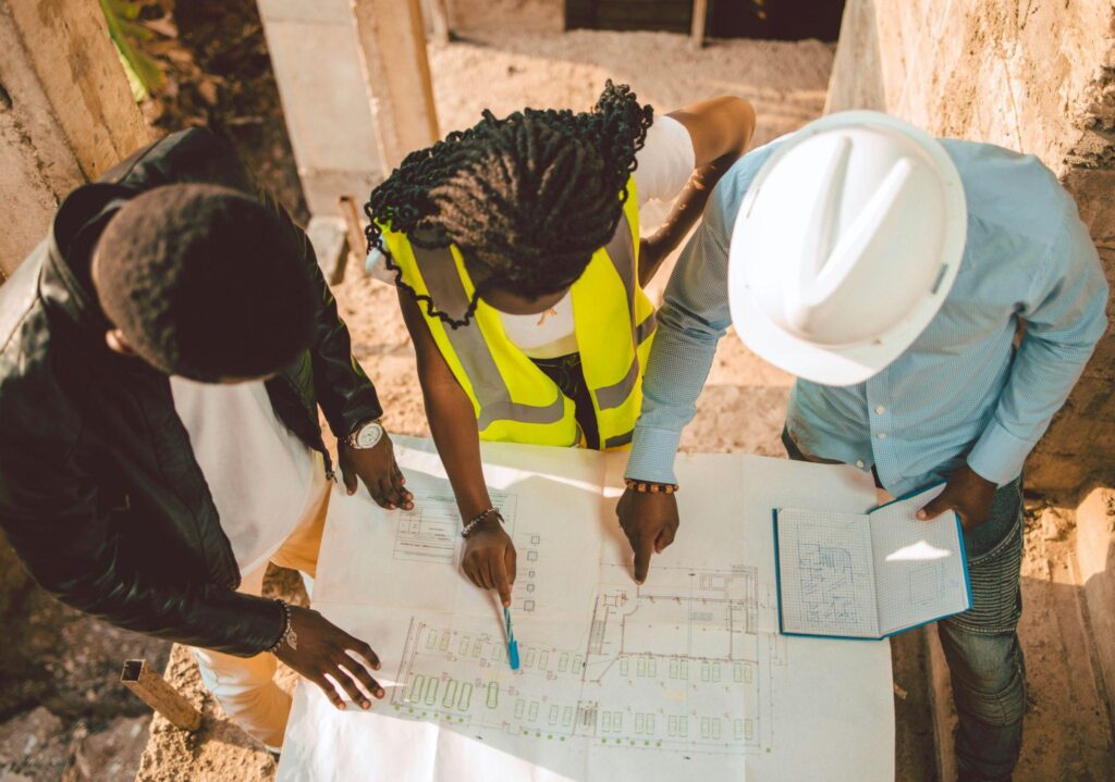 three workers reviewing construction plans