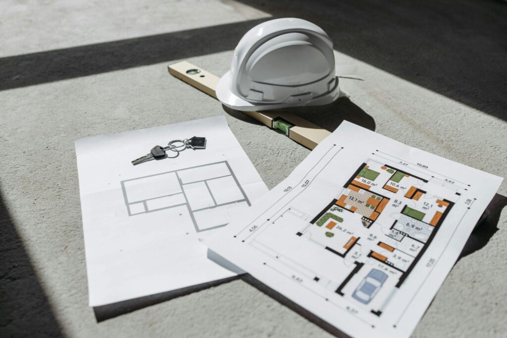 construction plans and property keys on a grey floor