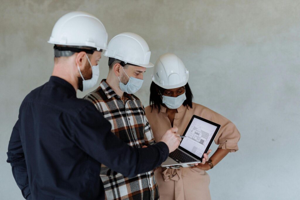 A trio of workers reviewing construction plans