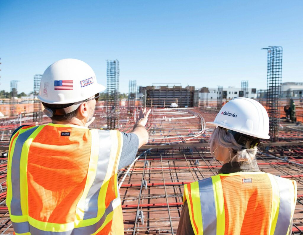 Two construction workers looking at a construction site