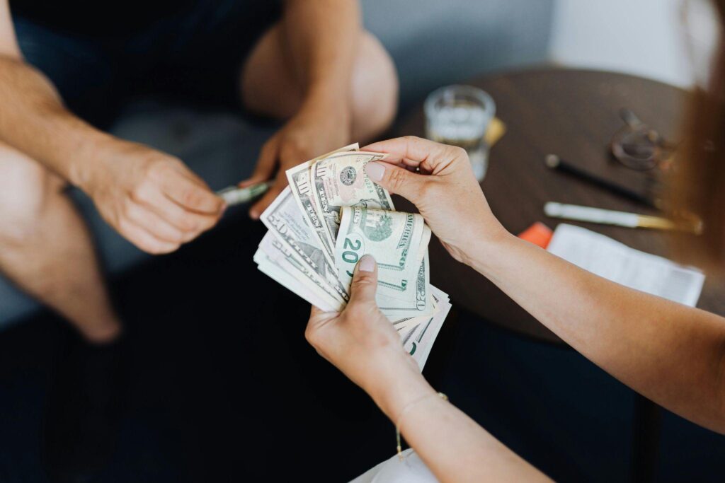 a person counting dollar bills