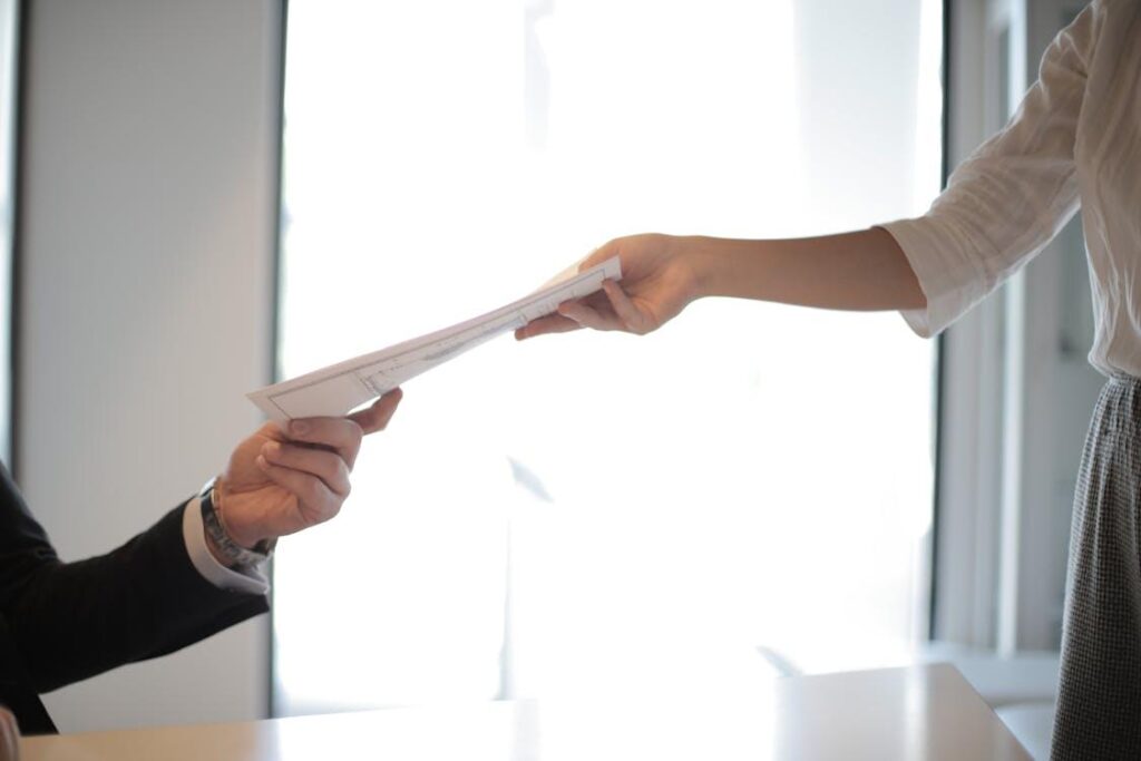 A person passing another person documents