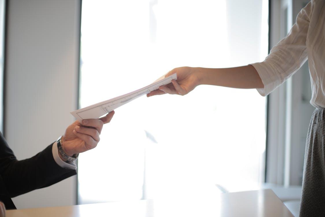 A person passing another person documents