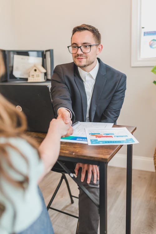 Two professionals shaking hands over a real estate deal