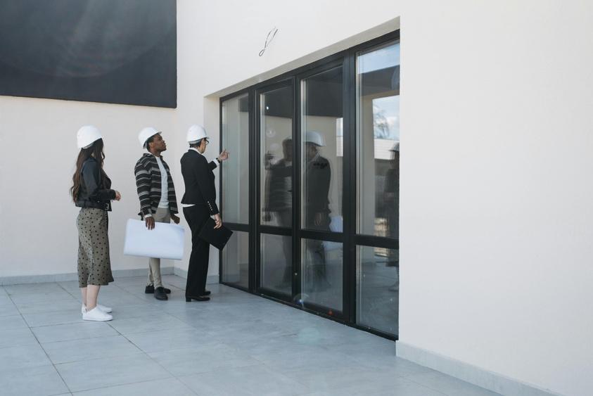 Clients discussing house windows while viewing a property for sale