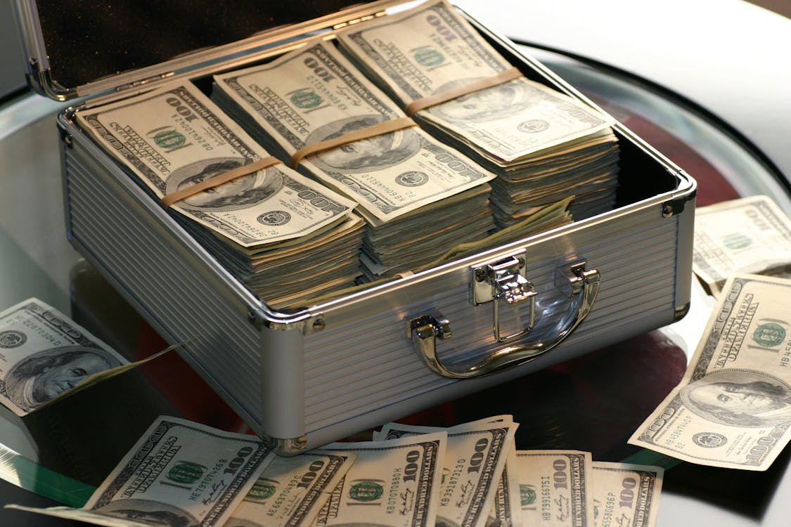 Briefcase filled with stacks of U.S. dollar bills on a table