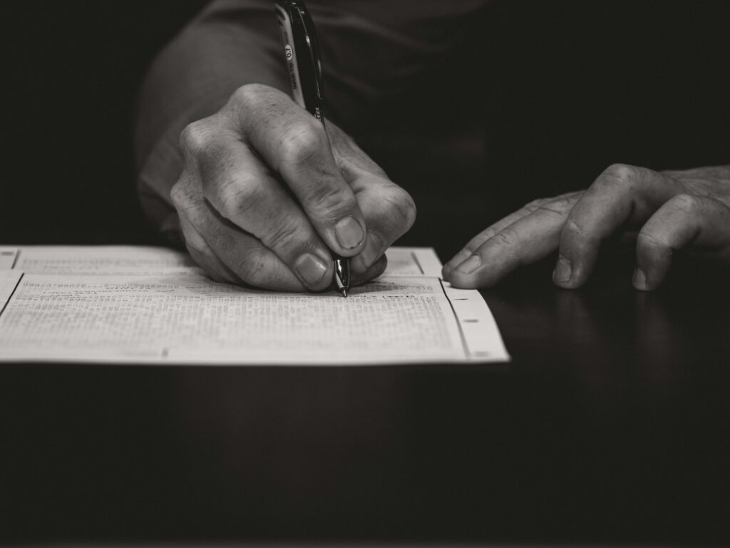 A person signing a form on the table