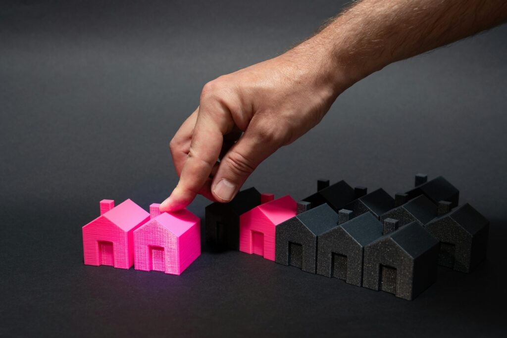 A person touching pink colored block houses