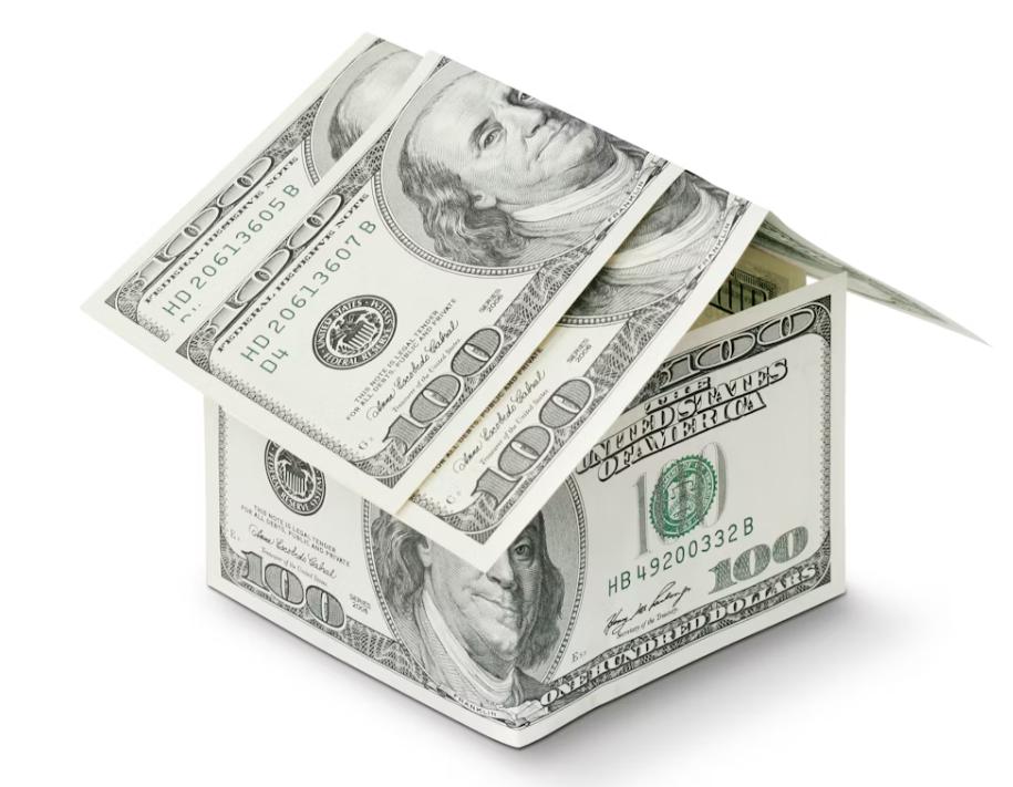 This image shows a house made of money on a white background