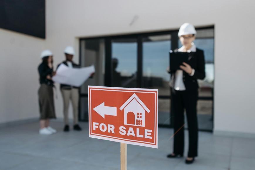Red for sale sign displayed outside a residential property