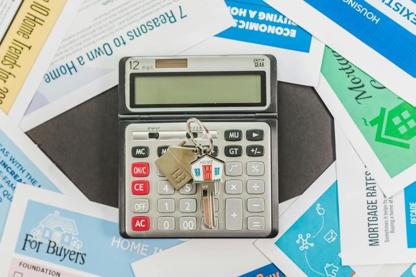 Calculator and real estate flyers showing mortgage and buyer information