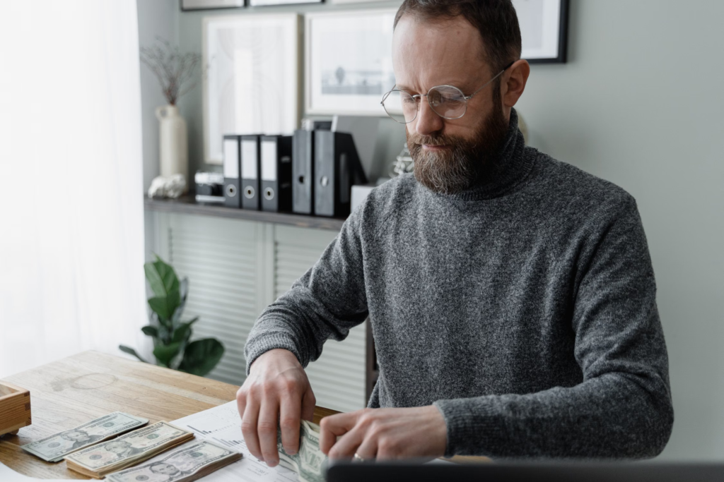 Financial advisor counting cash at office desk