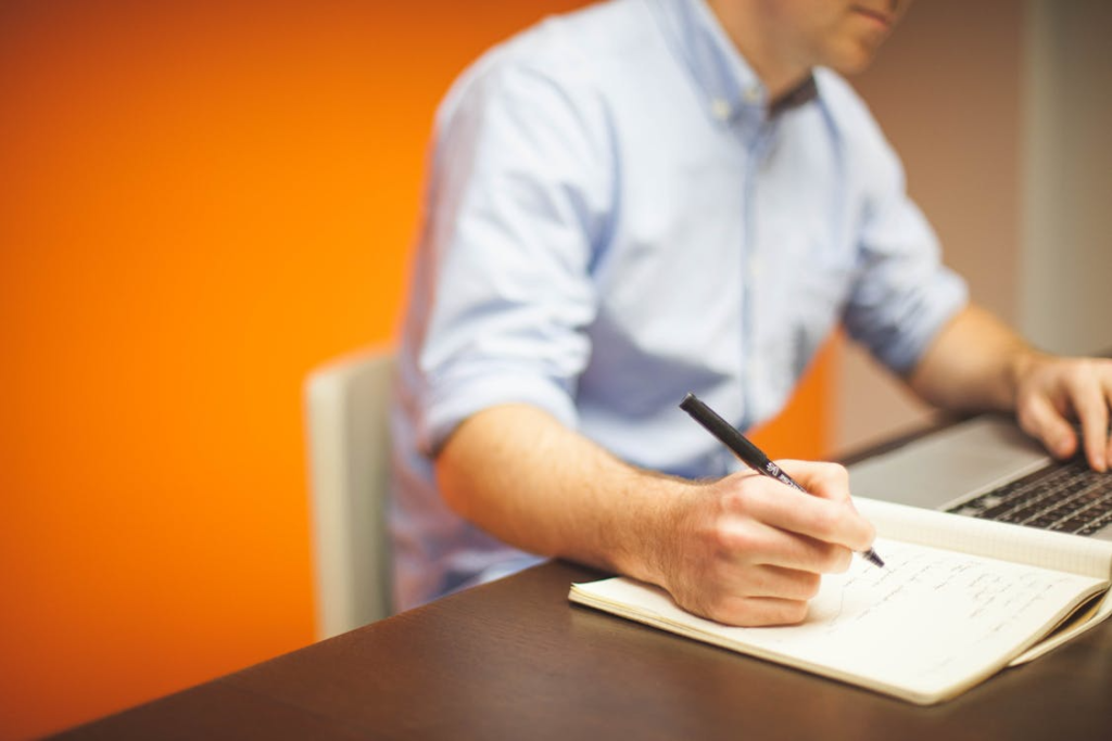 An image of a person writing in a notebook