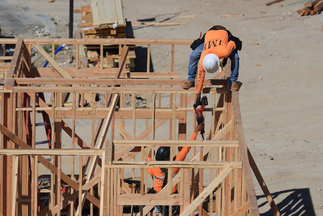 Construction workers assembling a wood-framing structure during the early residential building phase