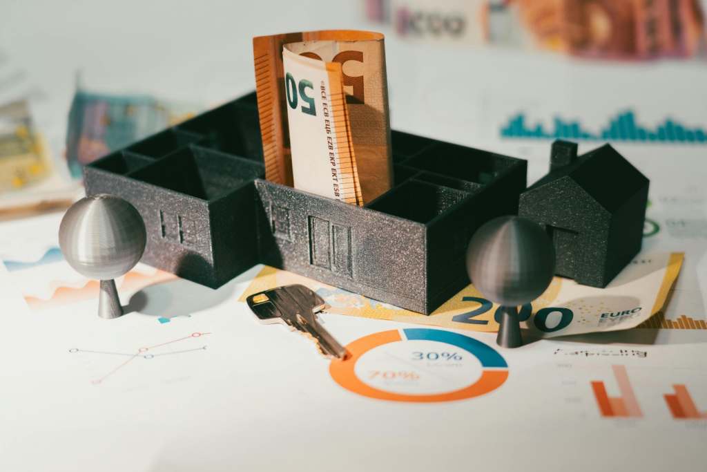 A photo showing a miniature home model placed next to banknotes