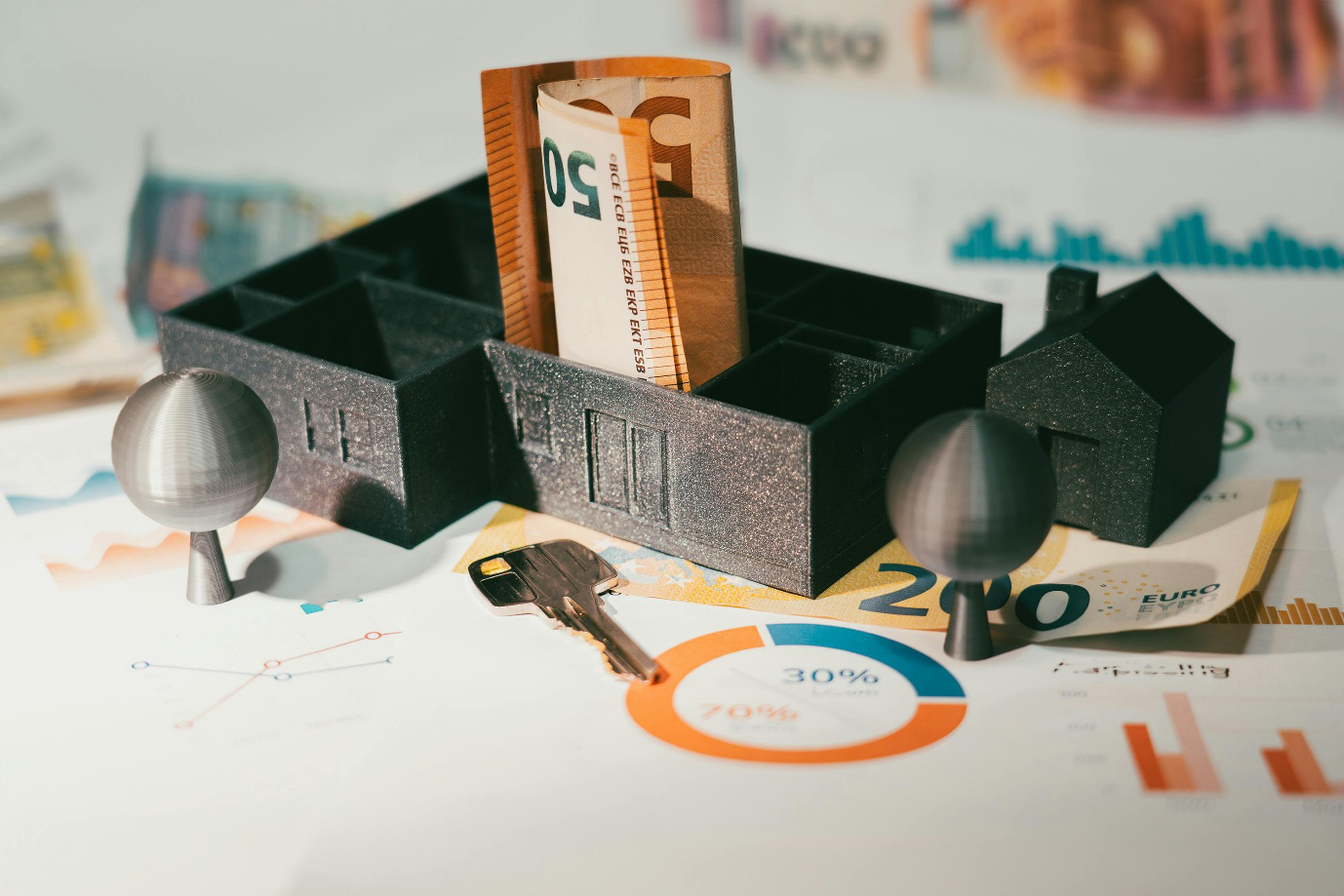 A photo showing a miniature home model placed next to banknotes