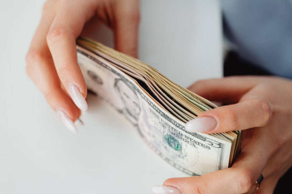 a woman holding a stack of cash