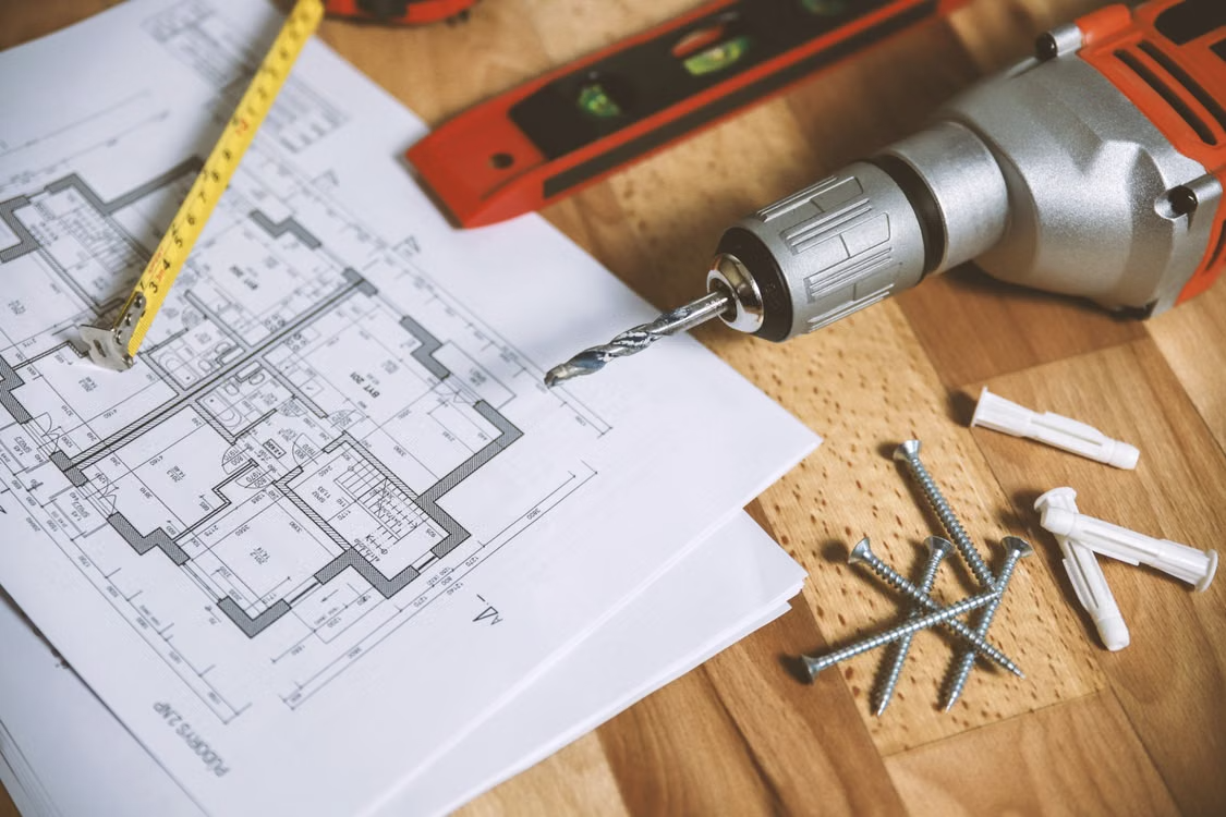 close-up of construction tools and floor plan on a table