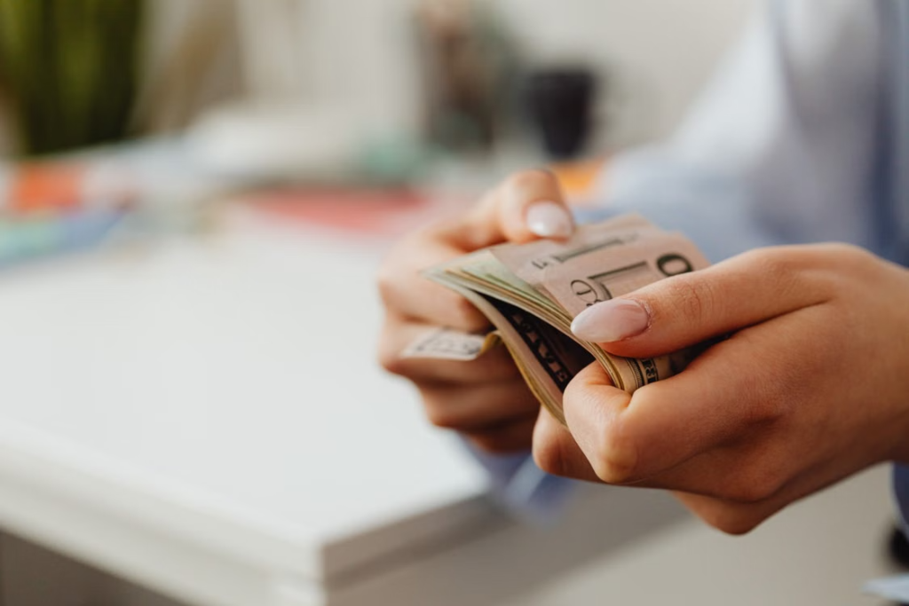 a person counting a stack of money