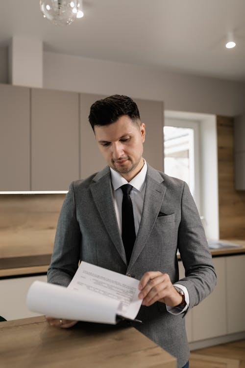 Real estate investor reviewing financing documents near a renovated property interior