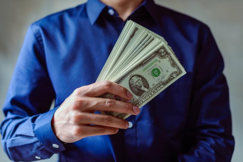A person holding US dollar bills